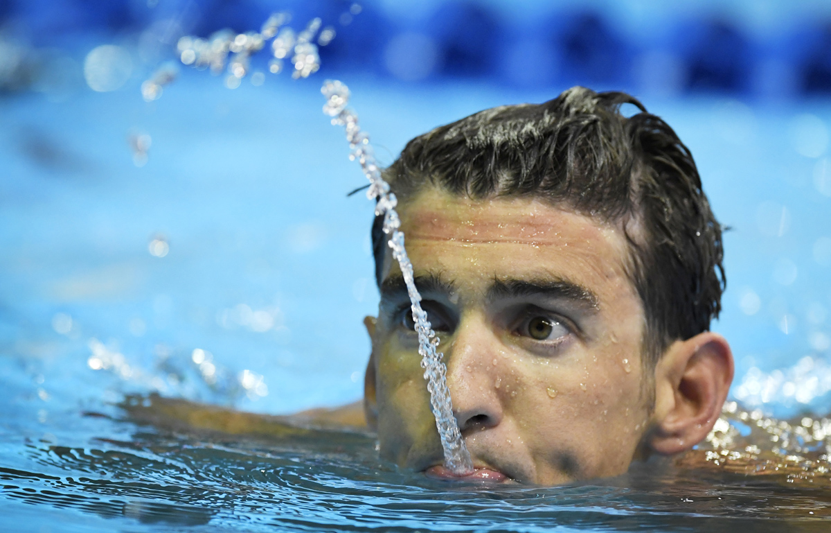 Michael Phelps spits water after swimming in the men's 200-meter individual medley preliminaries at the U.S. Olympic swimming trials, Thursday, June 30, 2016, in Omaha, Neb. (AP Photo/Mark J. Terrill)